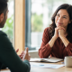 Sales professional listening during a consultative sales conversation in a modern office.